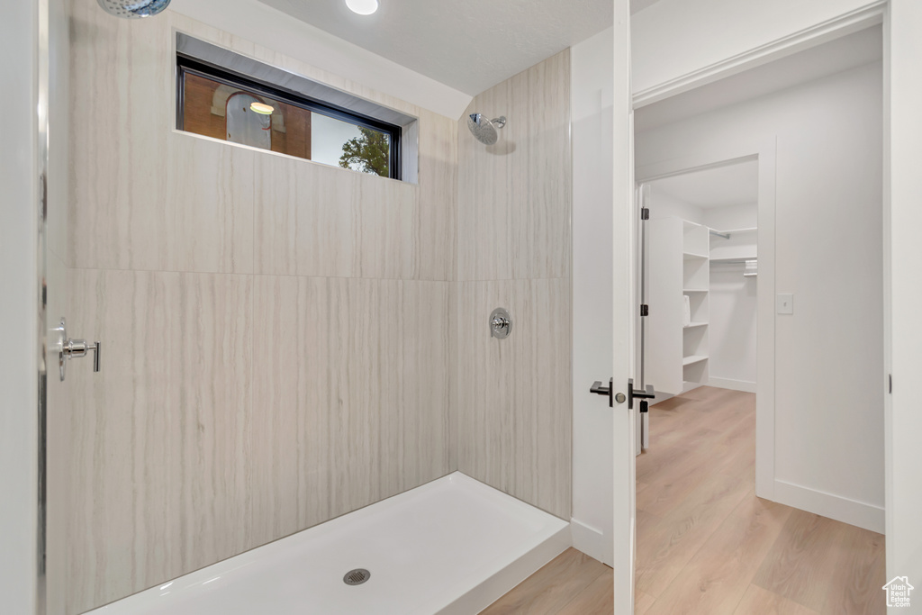 Bathroom with wood-type flooring and tiled shower