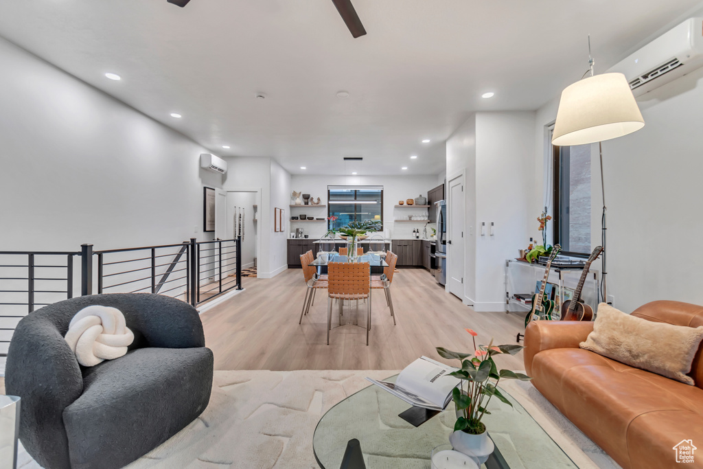 Living room with light hardwood / wood-style flooring and a wall unit AC