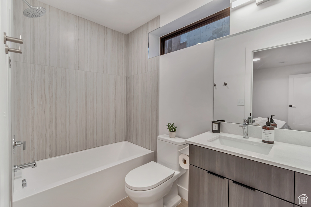 Full bathroom featuring vanity, toilet, and tiled shower / bath