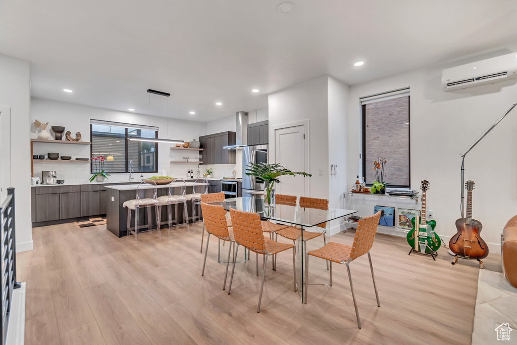 Dining space featuring light hardwood / wood-style flooring and a wall unit AC