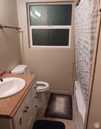 Full bathroom with vanity, shower / bath combo, and toilet