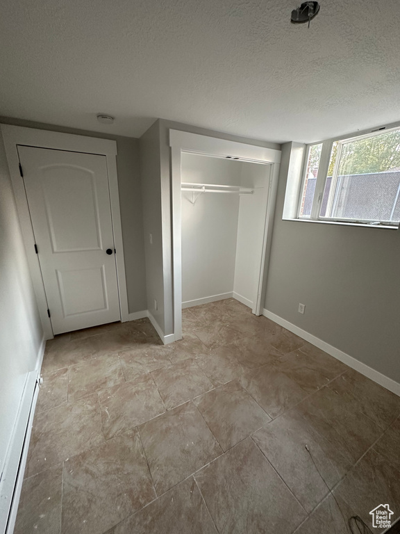 Unfurnished bedroom with a textured ceiling and a closet