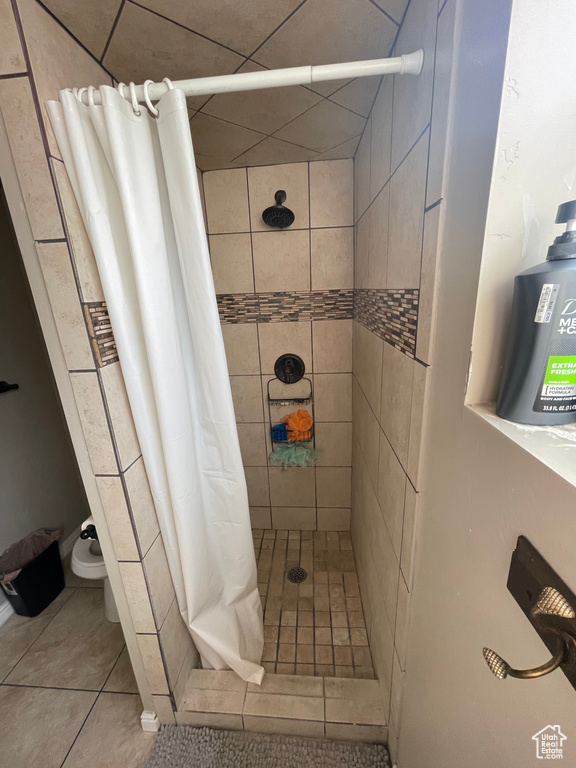 Bathroom featuring tile patterned floors and a shower with shower curtain