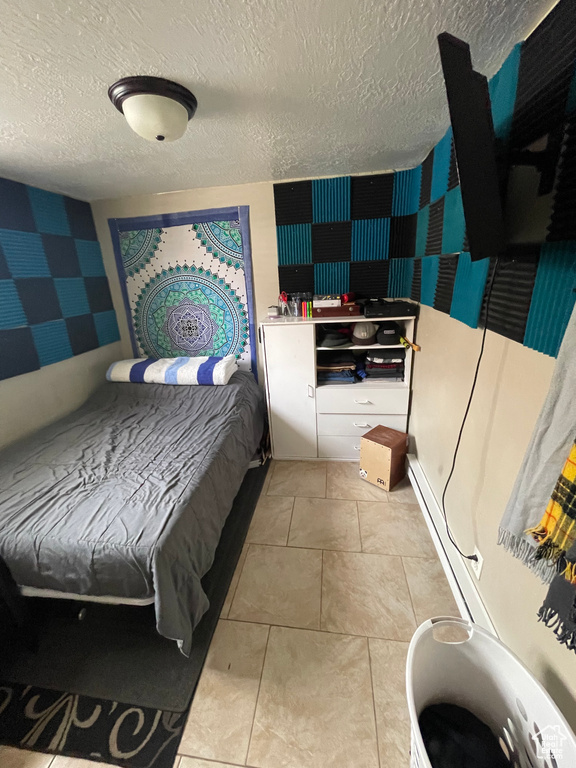 Tiled bedroom featuring a textured ceiling