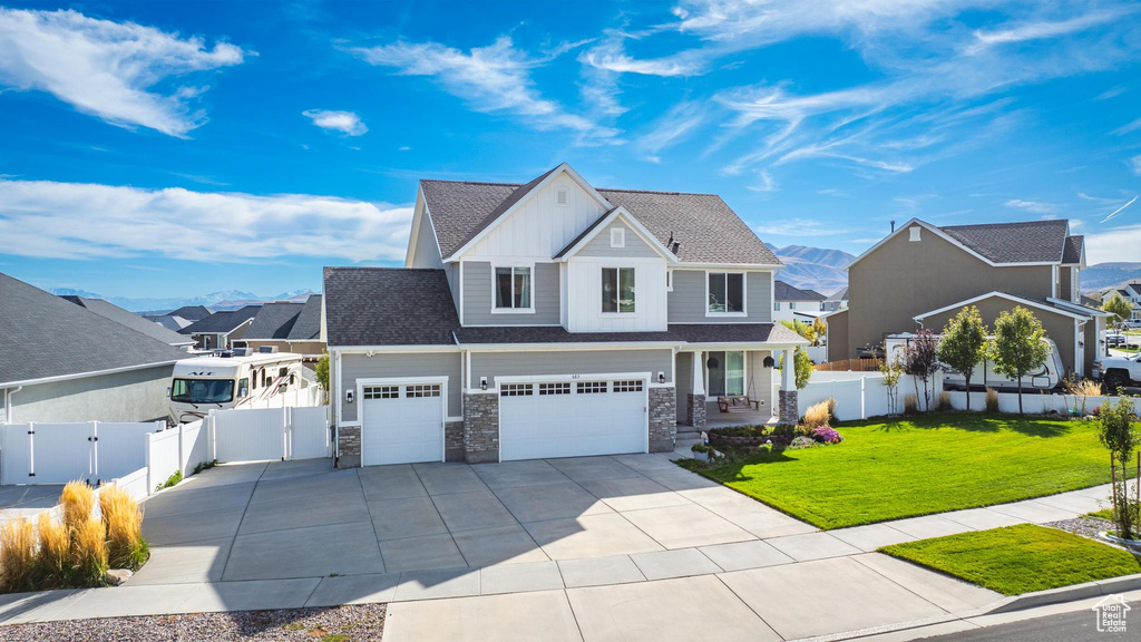 View of front of home with a mountain view, a garage, and a front lawn