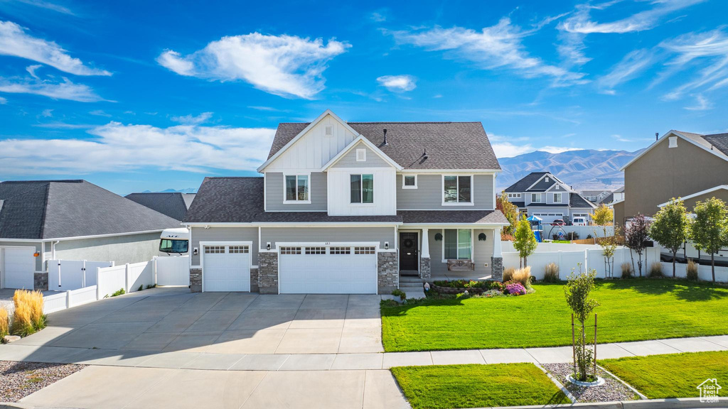 View of front facade with a mountain view, a front yard, and a garage