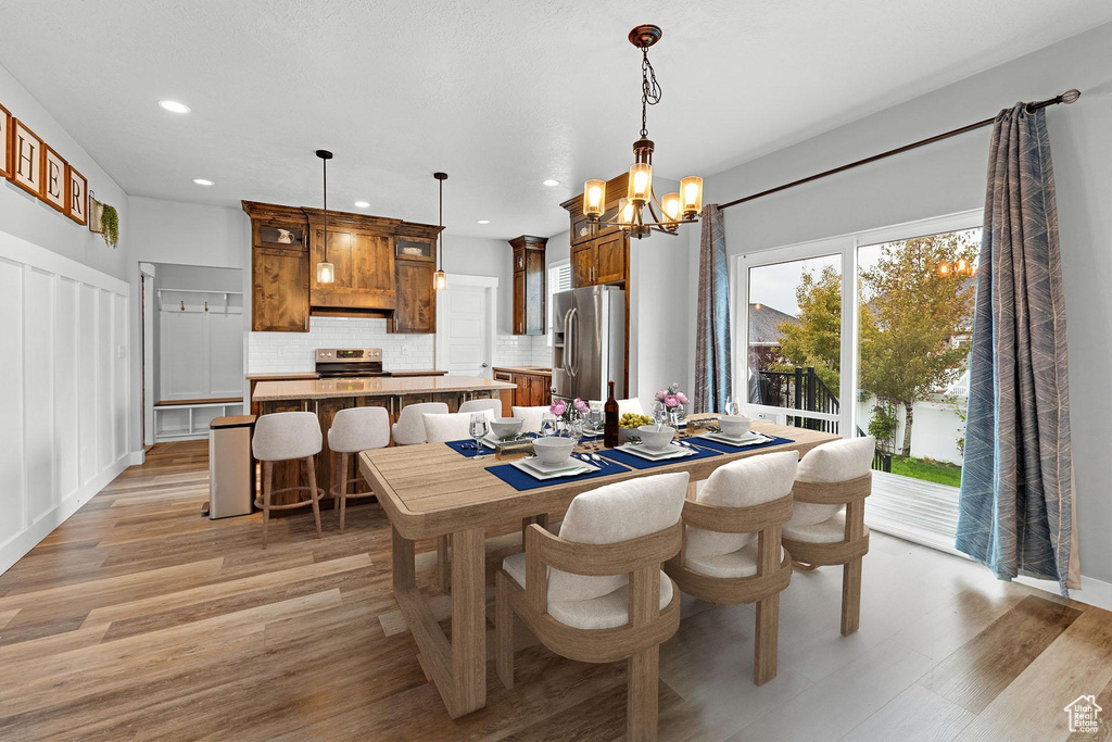 Dining area featuring light hardwood / wood-style flooring and an inviting chandelier