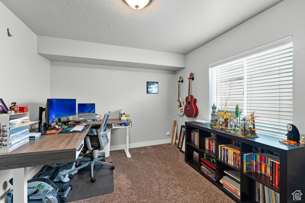 Home office featuring a textured ceiling and dark carpet