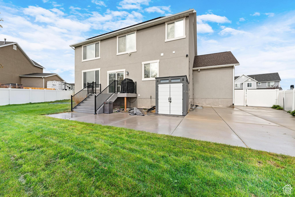 Back of property featuring a patio area and a lawn