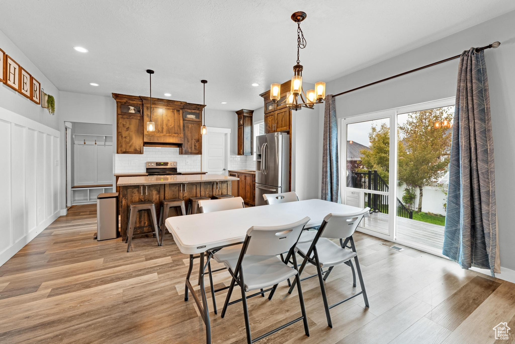 Dining space with a notable chandelier and light wood-type flooring