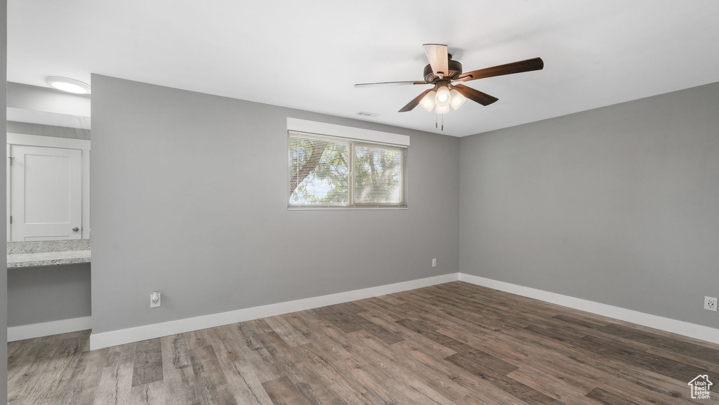 Spare room with dark wood-type flooring and ceiling fan