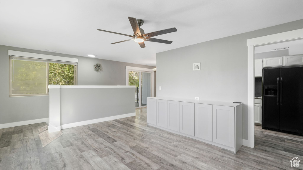 Empty room with light hardwood / wood-style floors, ceiling fan, and a wealth of natural light