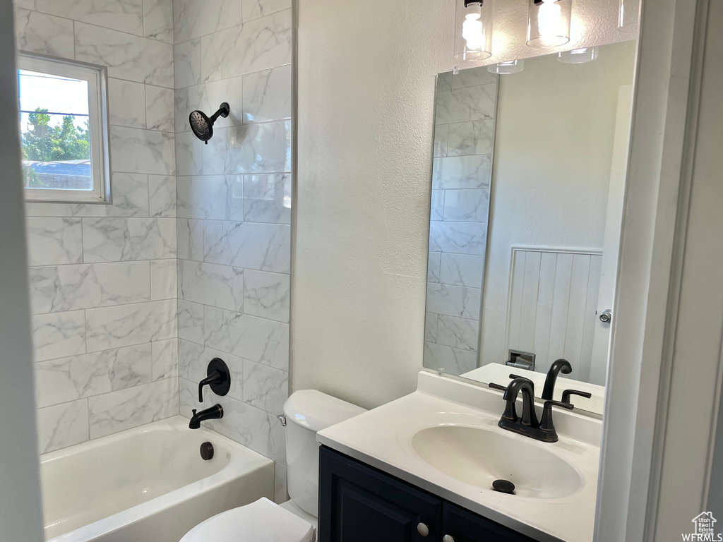 Full bathroom featuring toilet, tiled shower / bath, and vanity