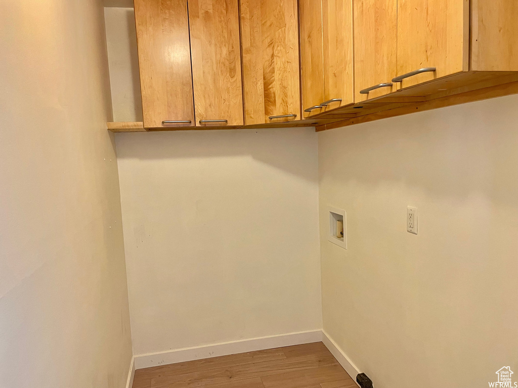 Clothes washing area featuring cabinets, hookup for a washing machine, and hardwood / wood-style floors