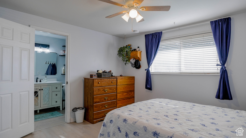 Bedroom with ensuite bath, light hardwood / wood-style floors, and ceiling fan