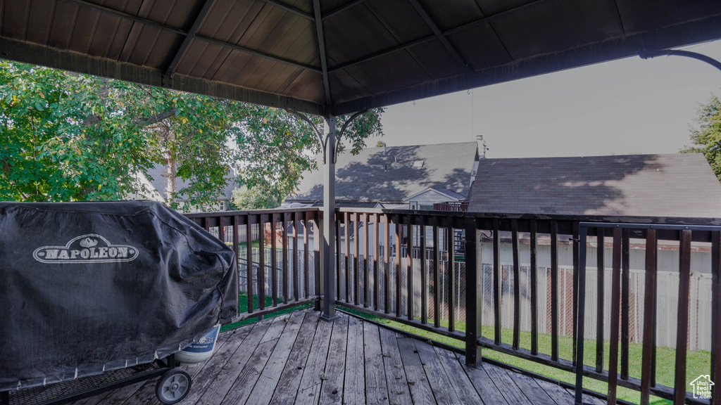 Wooden deck featuring a gazebo and a grill