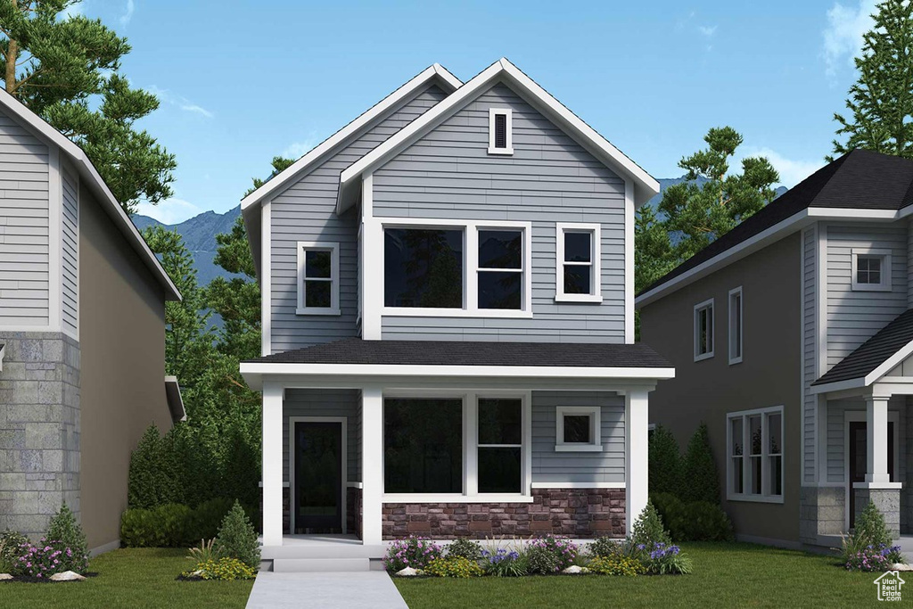 View of front facade featuring a mountain view, a front yard, and a porch