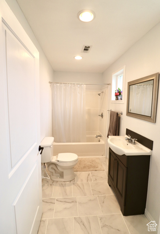 Full bathroom featuring toilet, vanity, and shower / bath combination with curtain