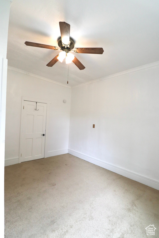 Carpeted empty room with crown molding and ceiling fan