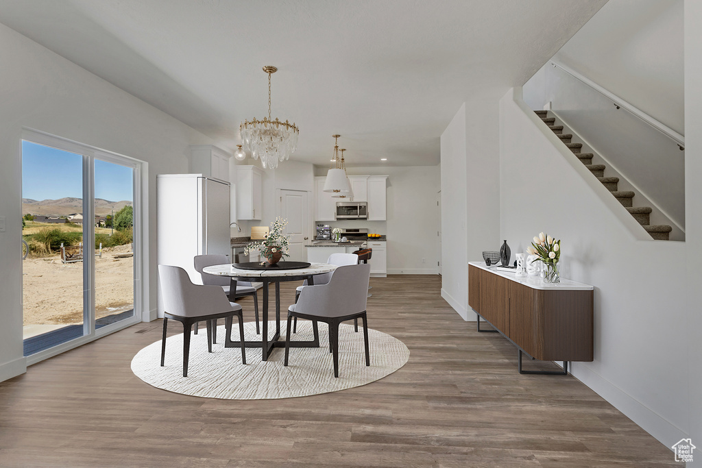 Dining room featuring light hardwood / wood-style floors, a notable chandelier, and a mountain view