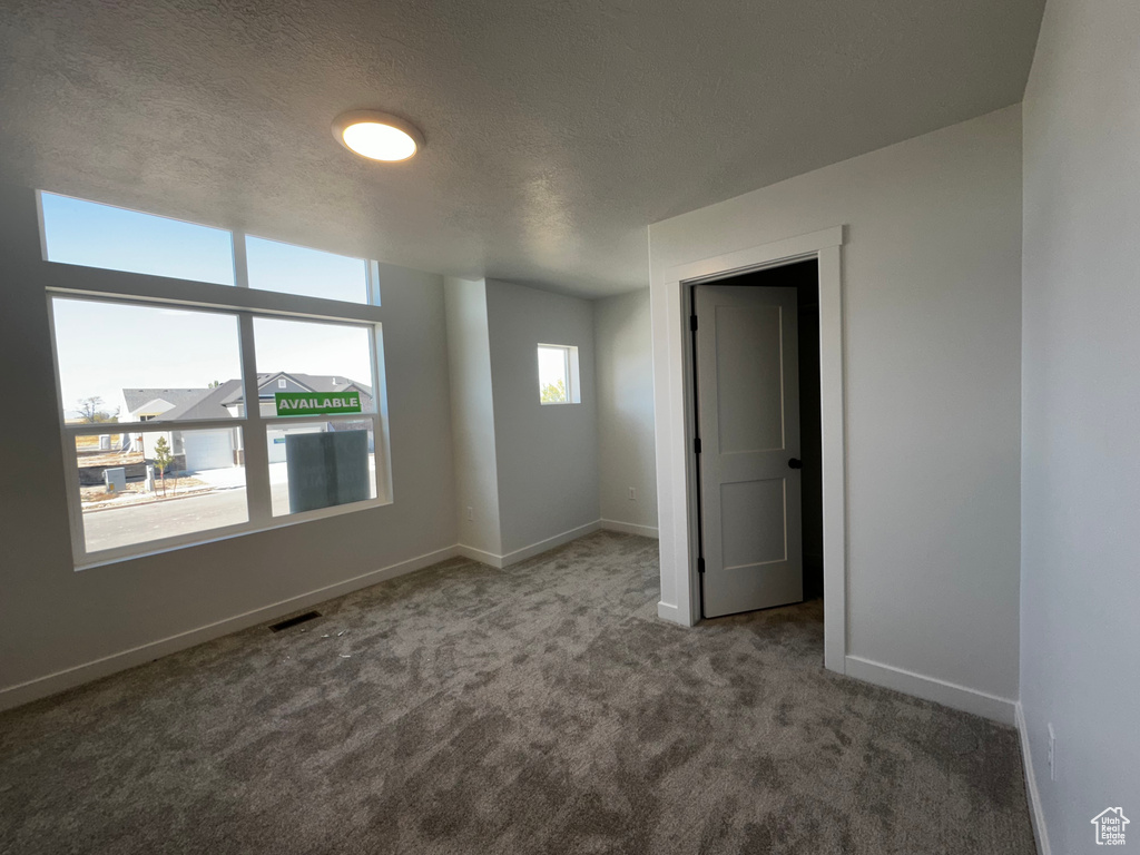 Spare room with a textured ceiling and carpet