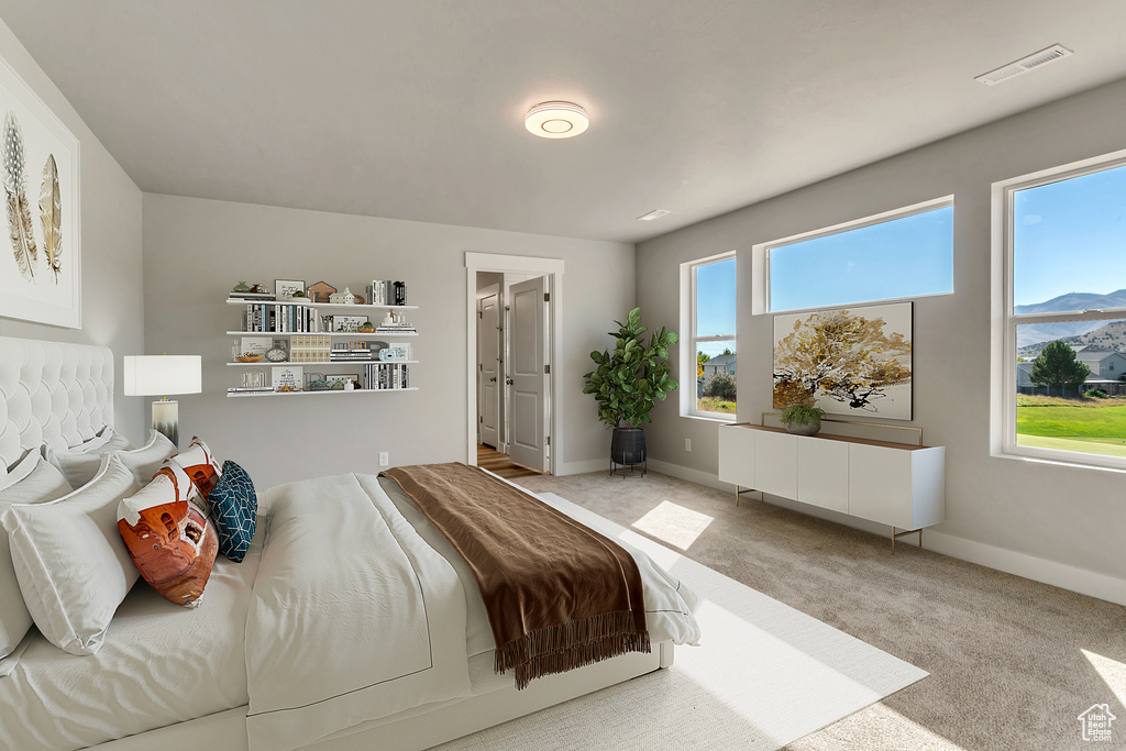 Bedroom with light carpet and a mountain view