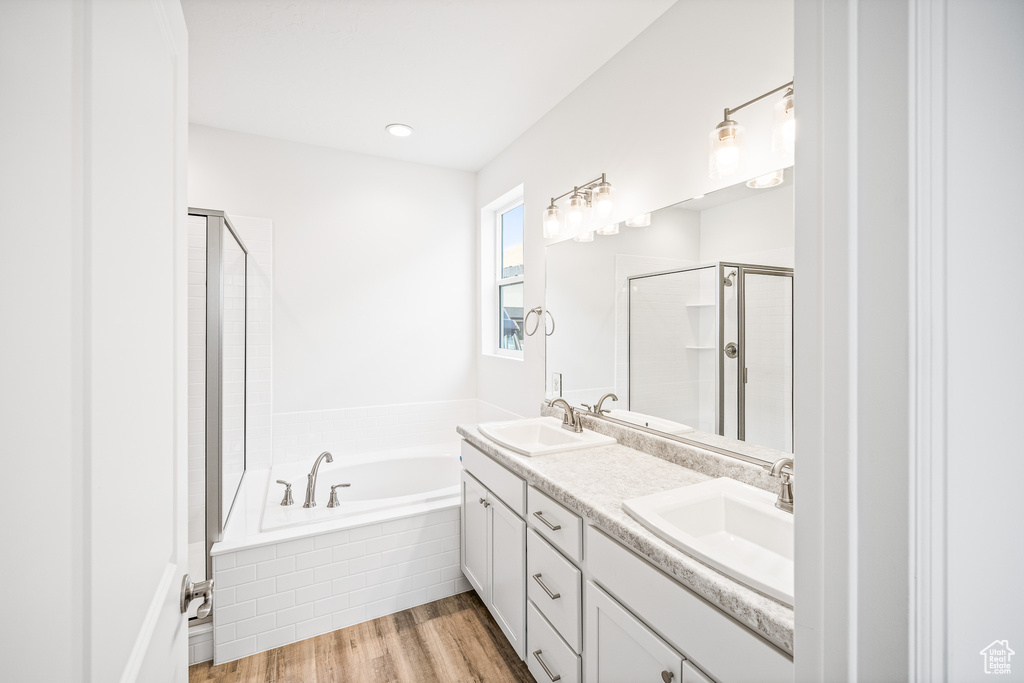 Bathroom with vanity, hardwood / wood-style flooring, and shower with separate bathtub