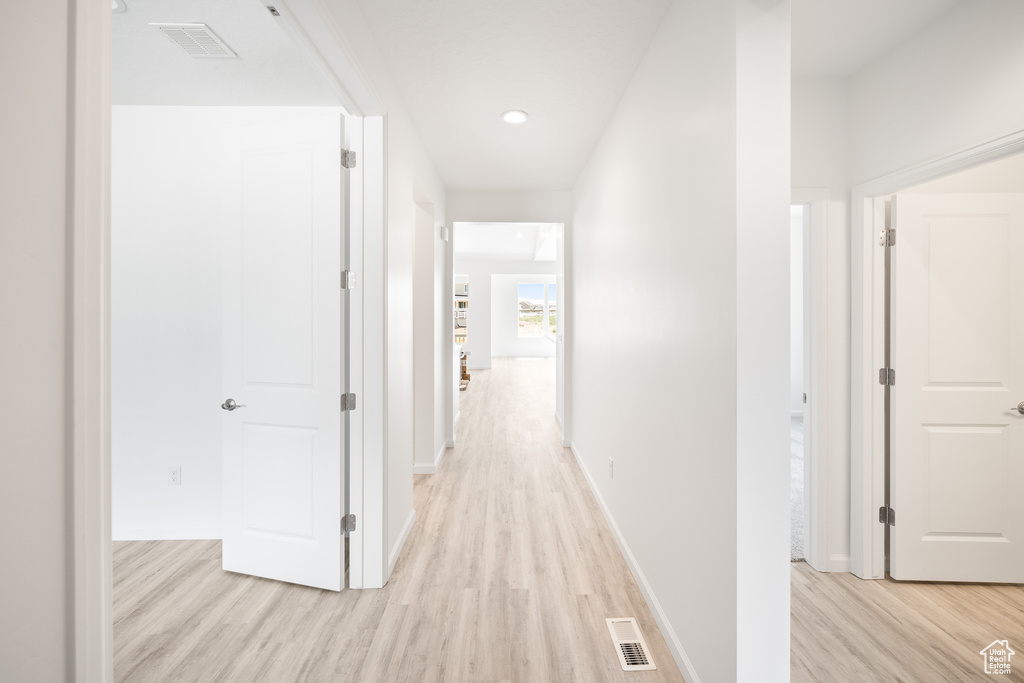 Hallway with light hardwood / wood-style floors