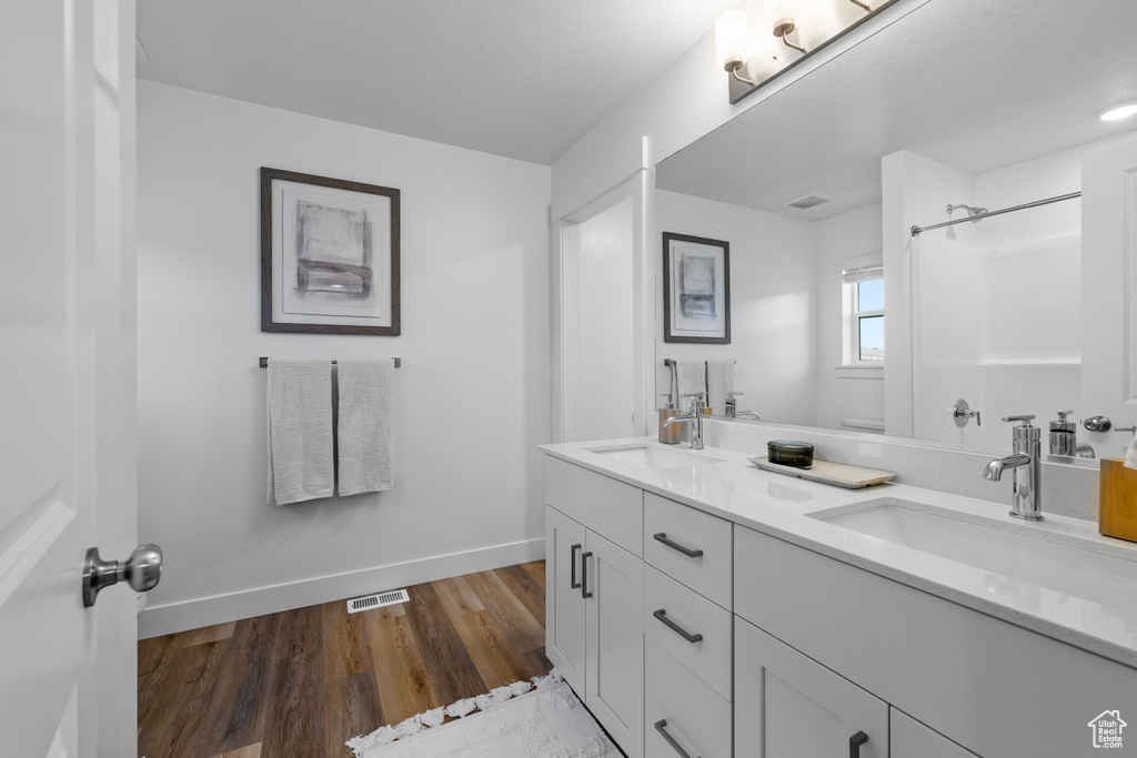 Bathroom with vanity, hardwood / wood-style floors, and walk in shower