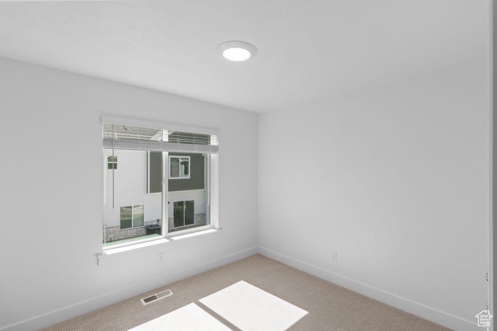 Carpeted spare room featuring plenty of natural light