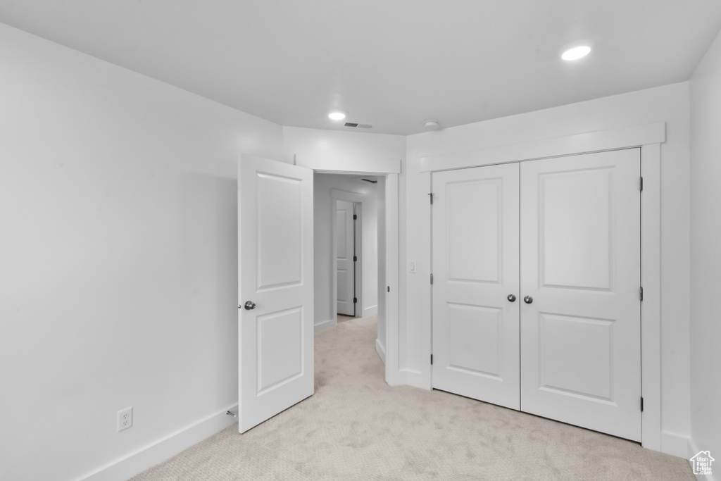 Unfurnished bedroom with a closet and light carpet