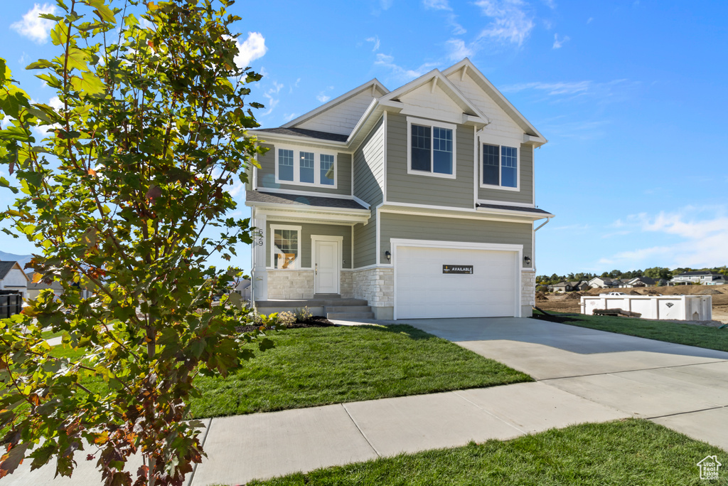 View of front of house featuring a front lawn and a garage