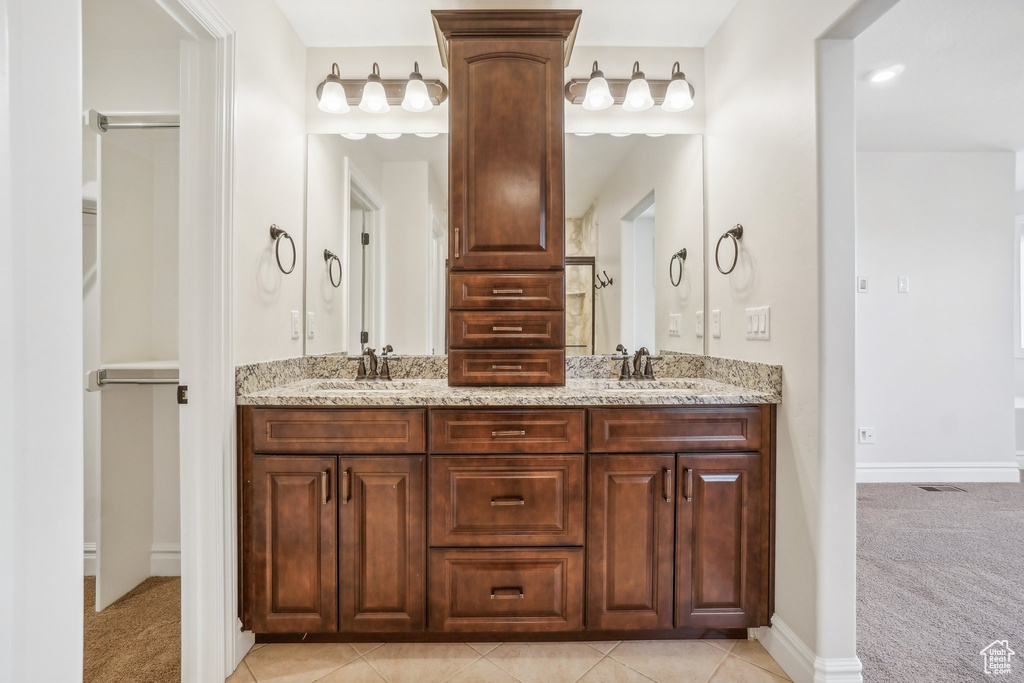 Bathroom with vanity, walk in shower, and tile patterned flooring