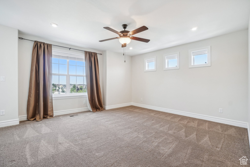 Carpeted empty room with ceiling fan