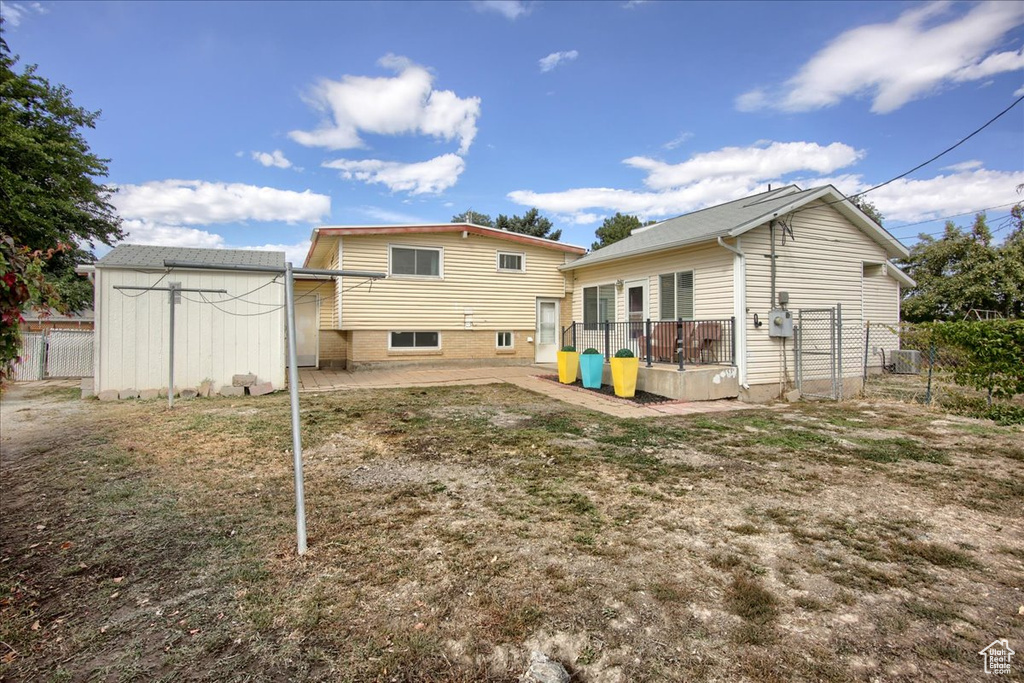 Rear view of property featuring a storage shed and a patio