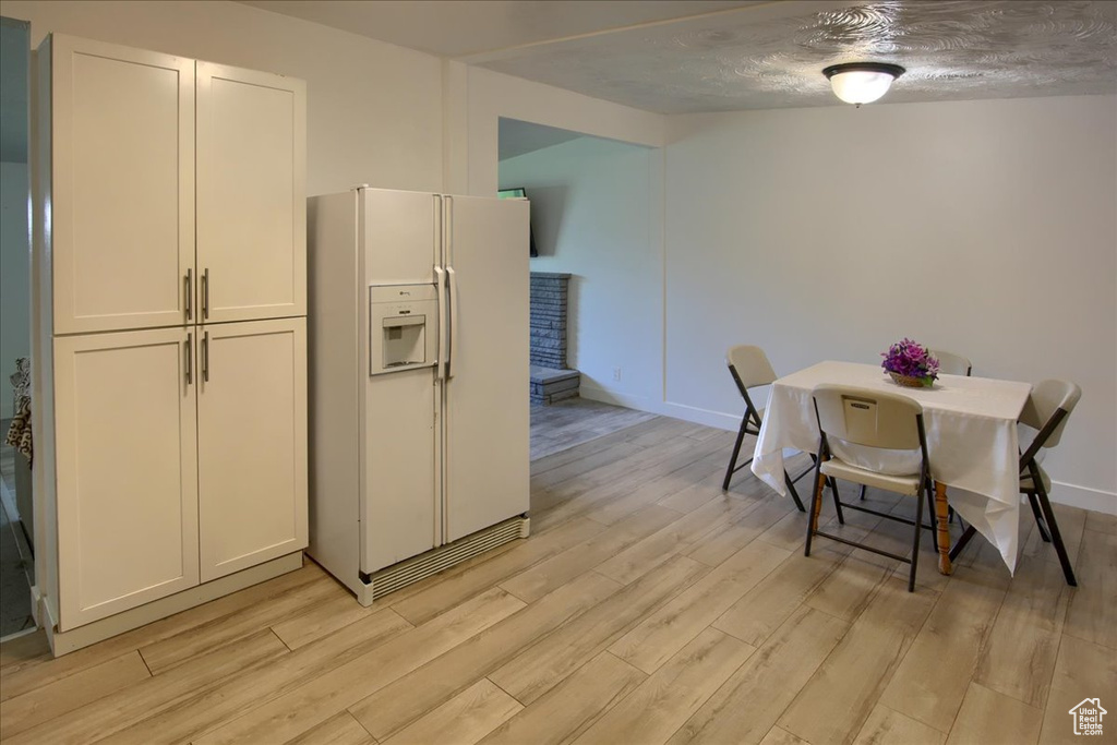 Dining area with light hardwood / wood-style floors and a textured ceiling