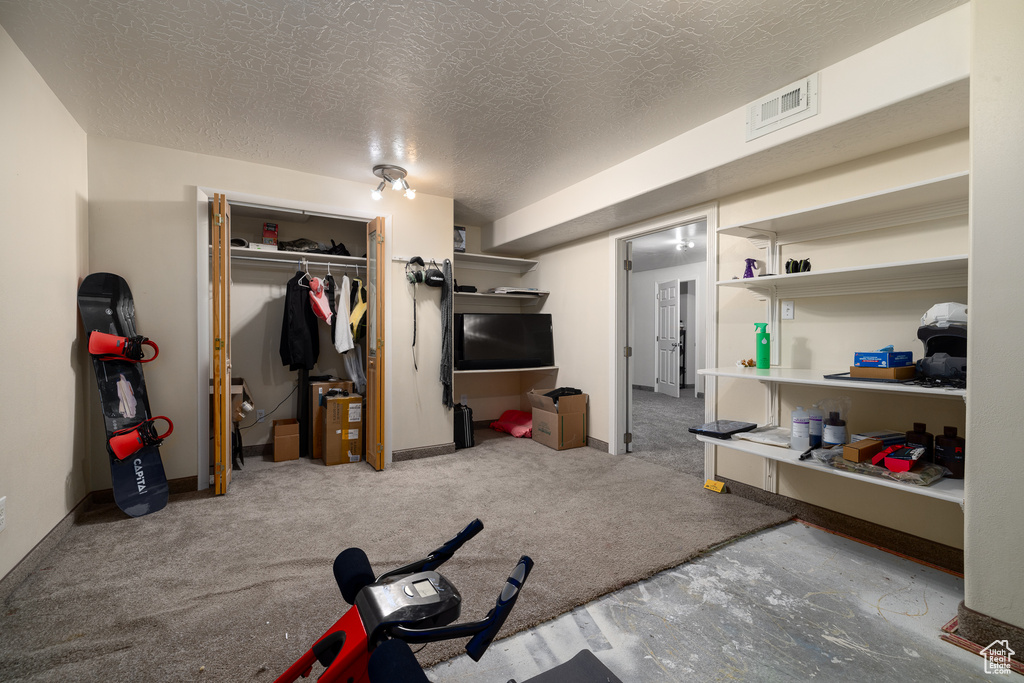 Interior space with carpet and a textured ceiling
