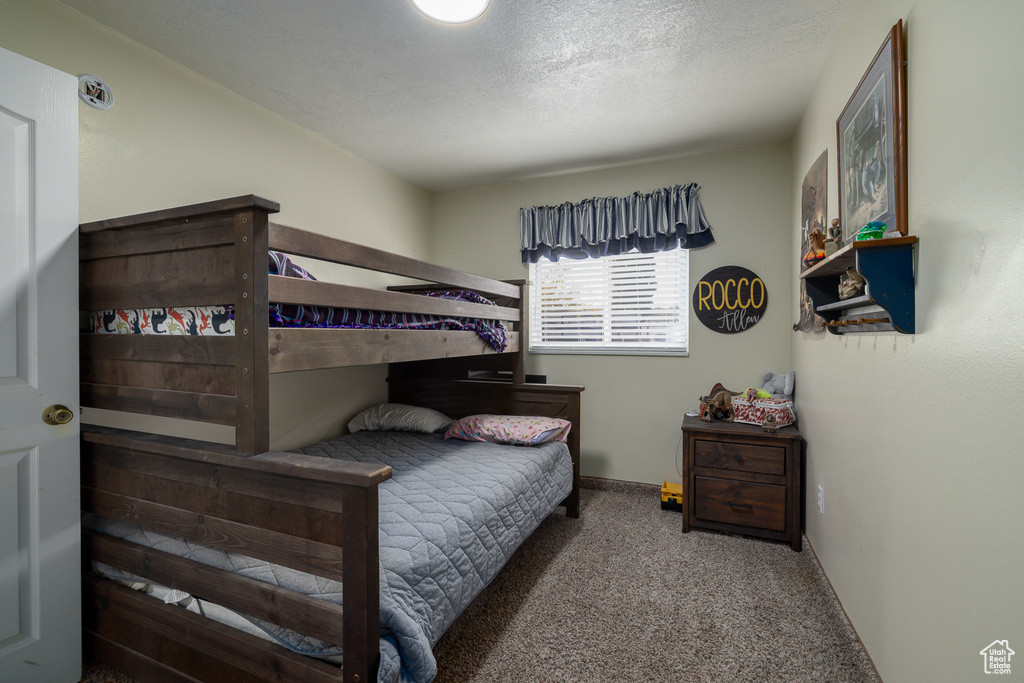 Bedroom with carpet and a textured ceiling