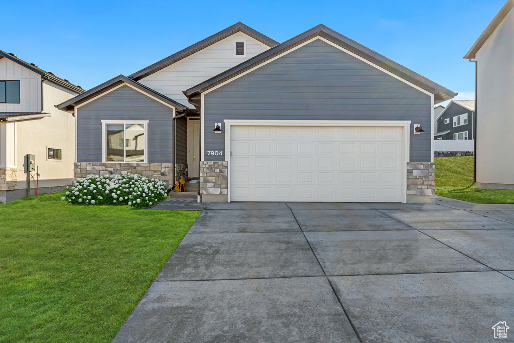 View of front of property with a front lawn and a garage