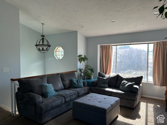 Living room with a notable chandelier, dark carpet, and a wealth of natural light