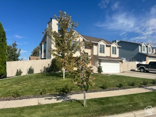 View of front of property with a front yard and a garage