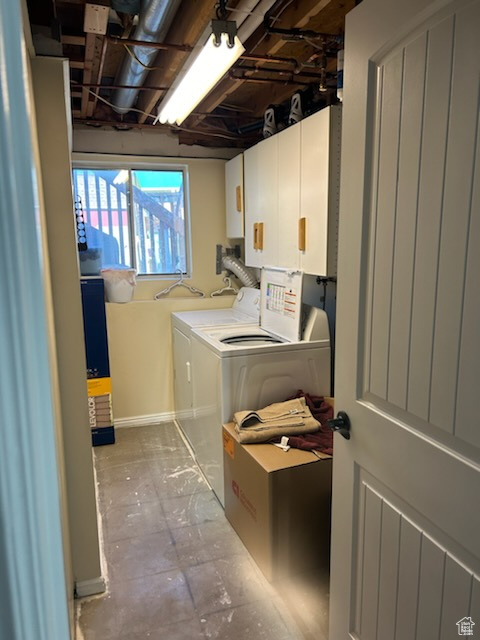 Laundry area featuring cabinets and washer and clothes dryer