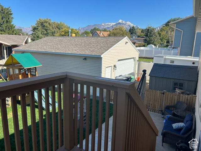 Wooden terrace featuring a mountain view and an outbuilding