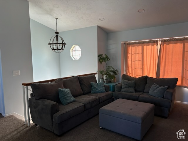 Living room featuring an inviting chandelier and dark carpet