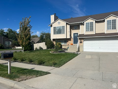 Raised ranch featuring a front yard and a garage