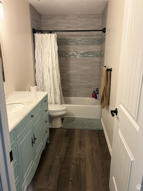 Full bathroom with vanity, toilet, shower / bath combination with curtain, and hardwood / wood-style floors