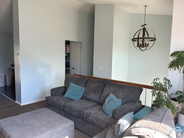 Carpeted living room with a chandelier and vaulted ceiling