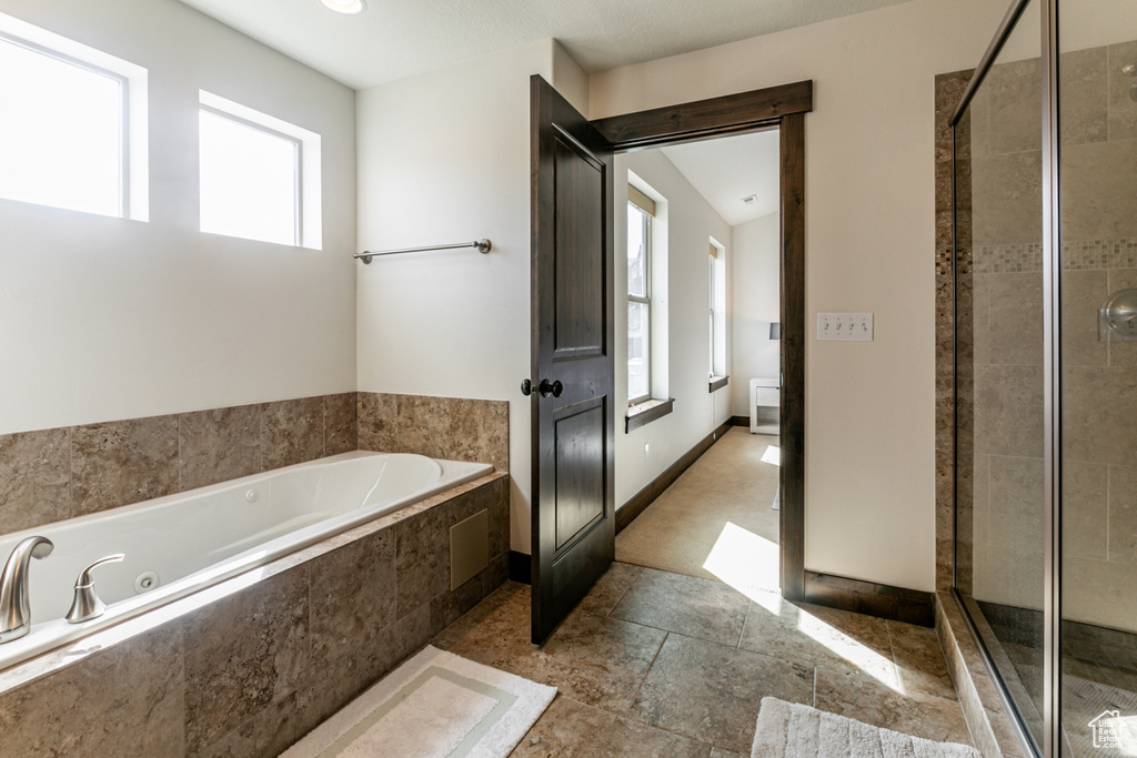 Bathroom with shower with separate bathtub and a wealth of natural light