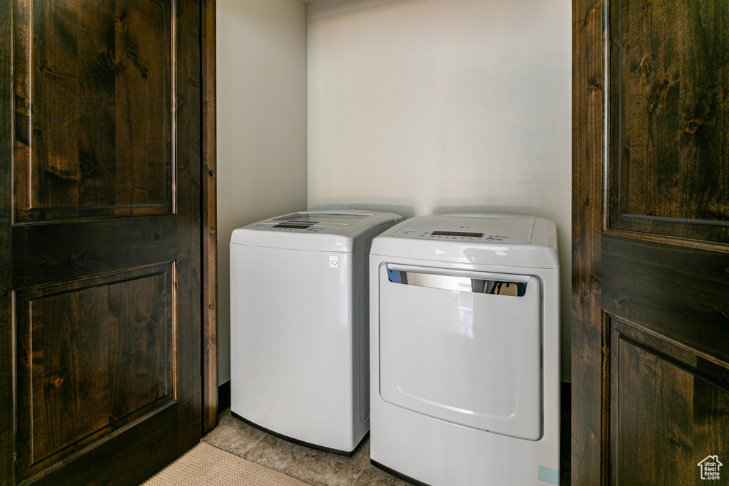 Washroom featuring independent washer and dryer and light tile patterned floors