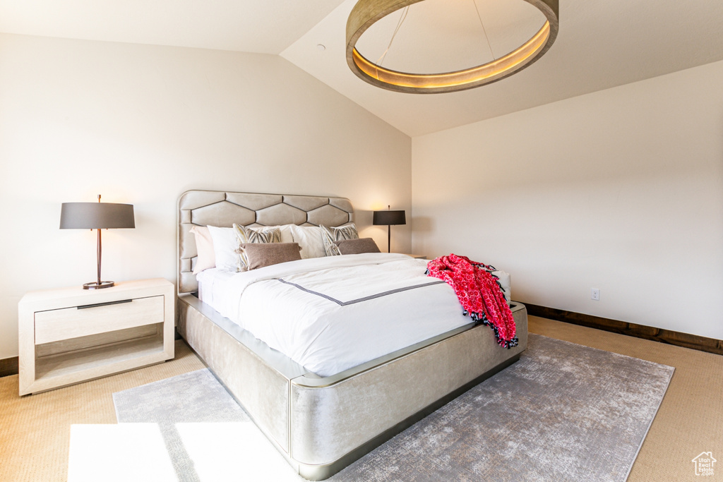 Bedroom with vaulted ceiling and light colored carpet